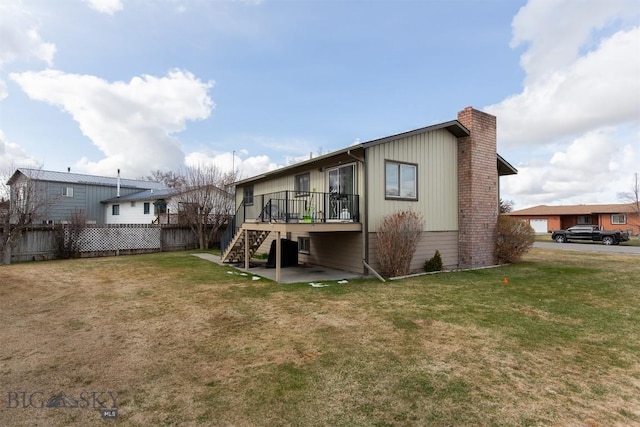 rear view of house featuring fence, a lawn, a deck, and stairway
