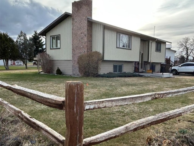 view of side of property with a lawn and a chimney