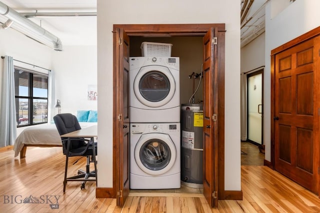 67 Village Dr Unit 4A, Belgrade, MT 59714 - laundry area featuring stacked washing machine and dryer, water heater, and light wood-style floors