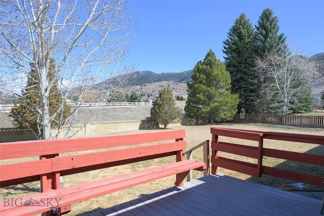 wooden deck with a mountain view and fence