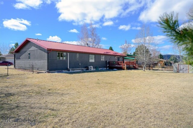 back of house featuring a lawn and metal roof