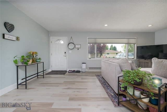 entryway with baseboards, recessed lighting, light wood-style floors, and a baseboard radiator