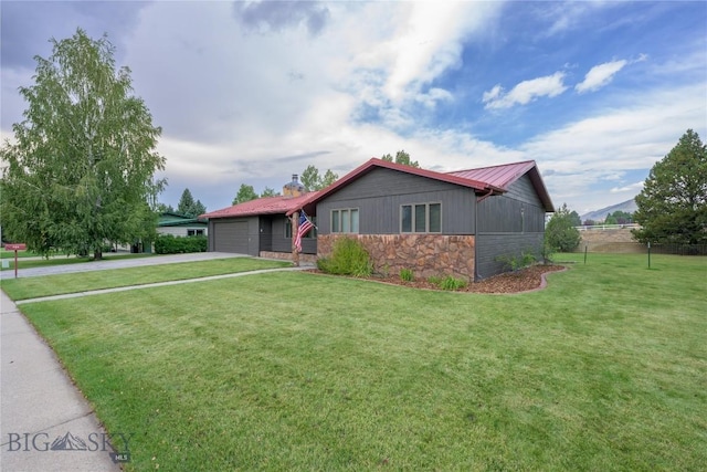 ranch-style house featuring a front lawn, driveway, stone siding, and a garage