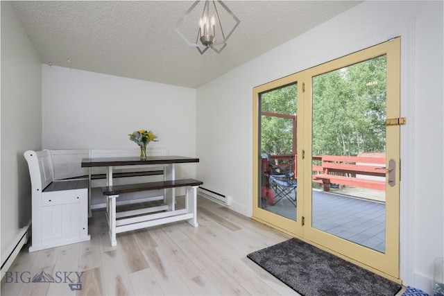 doorway featuring a baseboard radiator, light wood-style flooring, and a textured ceiling