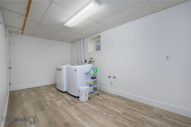 washroom featuring washing machine and clothes dryer, baseboards, laundry area, and wood finished floors