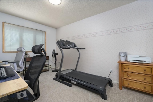 exercise area featuring baseboards, wallpapered walls, carpet, and a textured ceiling