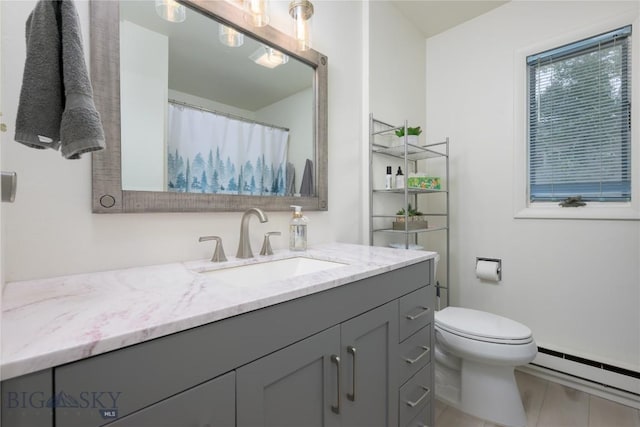 bathroom featuring toilet, vanity, and a baseboard radiator