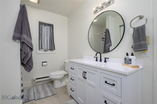 bathroom featuring a baseboard radiator, toilet, and vanity