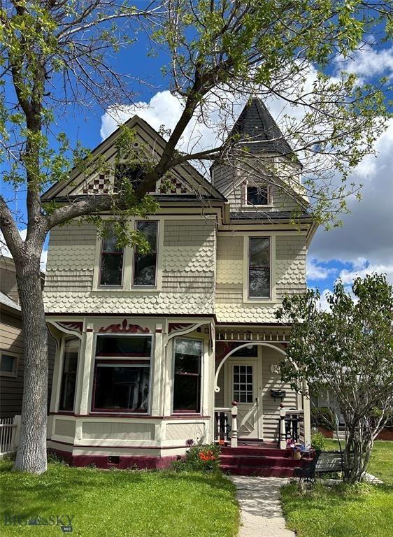victorian-style house featuring a front lawn and a porch