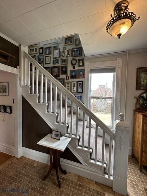 staircase with baseboards and ornamental molding