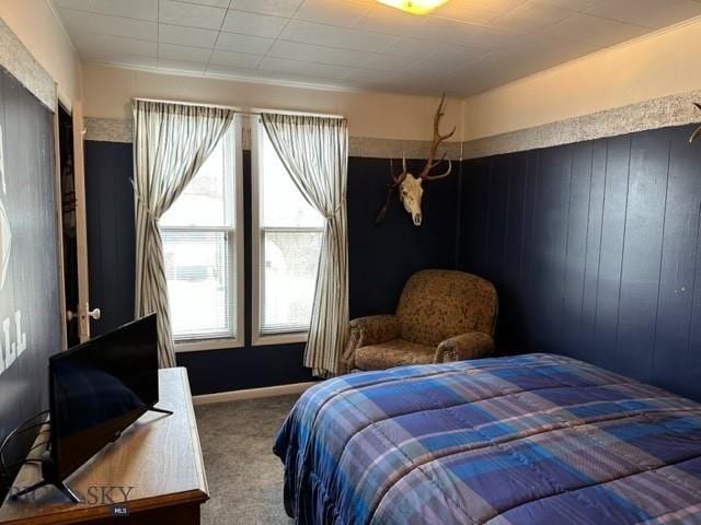 carpeted bedroom featuring wooden walls