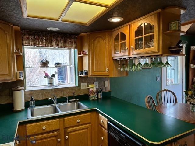 kitchen with open shelves, backsplash, a sink, black dishwasher, and glass insert cabinets