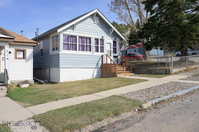bungalow with fence and a front lawn