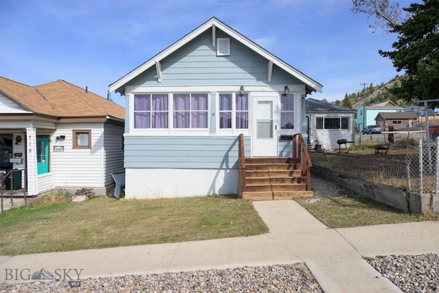 bungalow featuring fence and a front yard