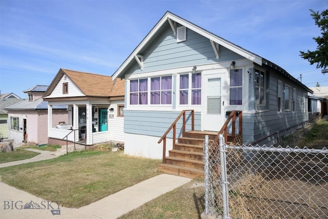 bungalow-style house with fence and a front lawn