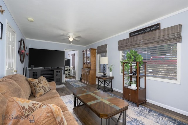 living room with baseboards, ceiling fan, ornamental molding, and wood finished floors