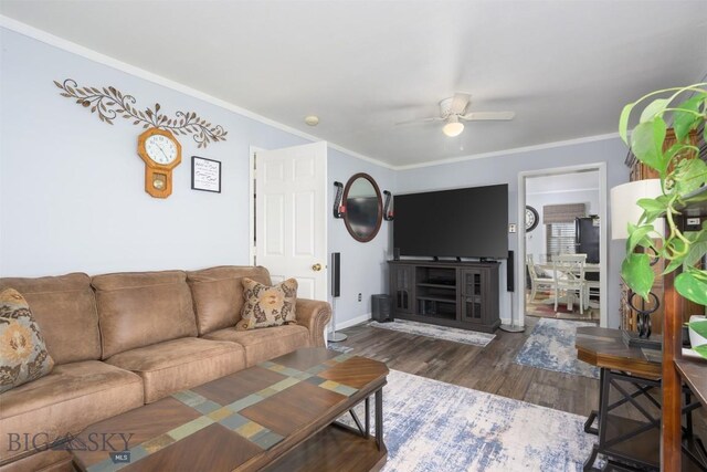 living area featuring crown molding, baseboards, ceiling fan, and wood finished floors