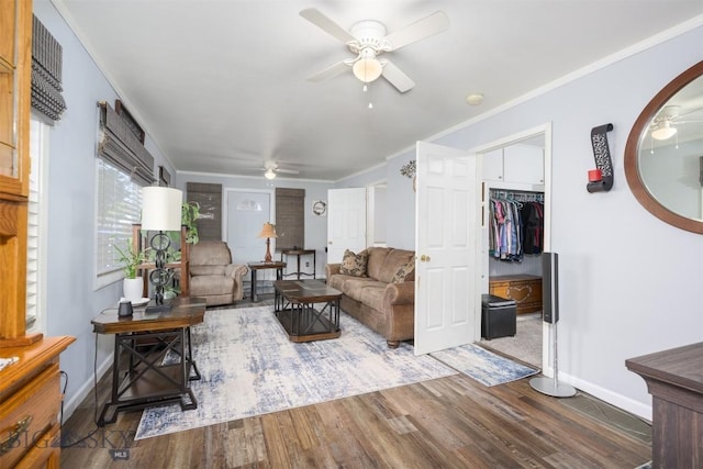 living room featuring crown molding, baseboards, a ceiling fan, and wood finished floors