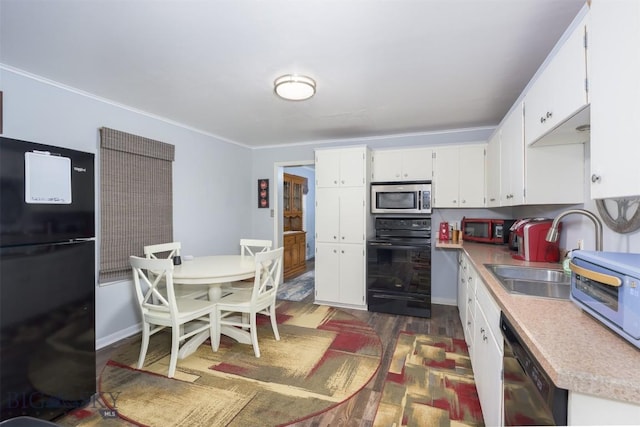 kitchen featuring dark wood finished floors, a sink, light countertops, black appliances, and white cabinetry