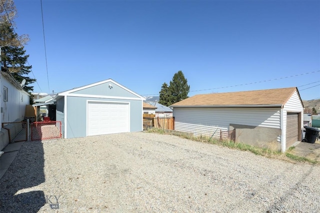 detached garage with fence and driveway