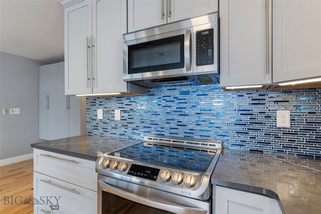211 N Yellowstone Ave, Bozeman, MT 59718 - kitchen with stainless steel appliances, backsplash, baseboards, and light wood-type flooring