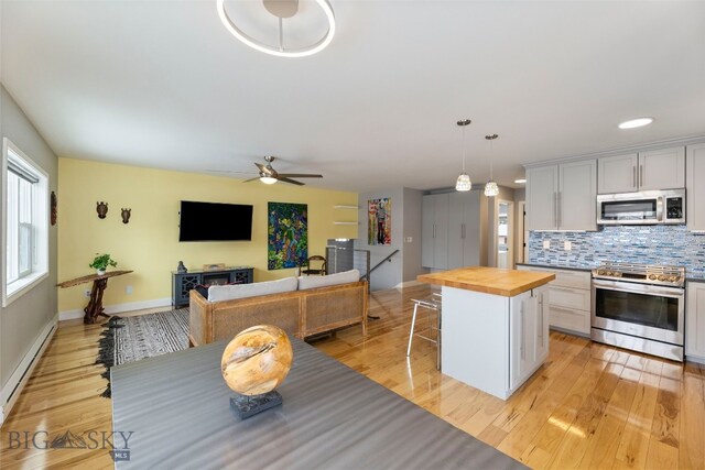 211 N Yellowstone Ave, Bozeman, MT 59718 - kitchen with appliances with stainless steel finishes, wood counters, a baseboard heating unit, and baseboards