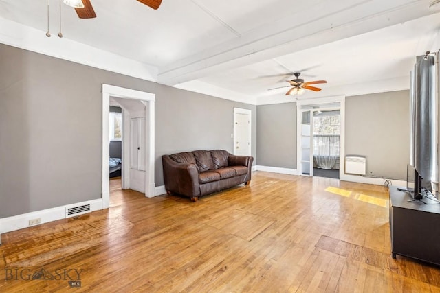 living room with baseboards, visible vents, a ceiling fan, and light wood finished floors