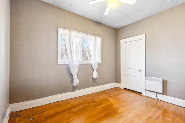 unfurnished bedroom featuring a ceiling fan, hardwood / wood-style flooring, and baseboards