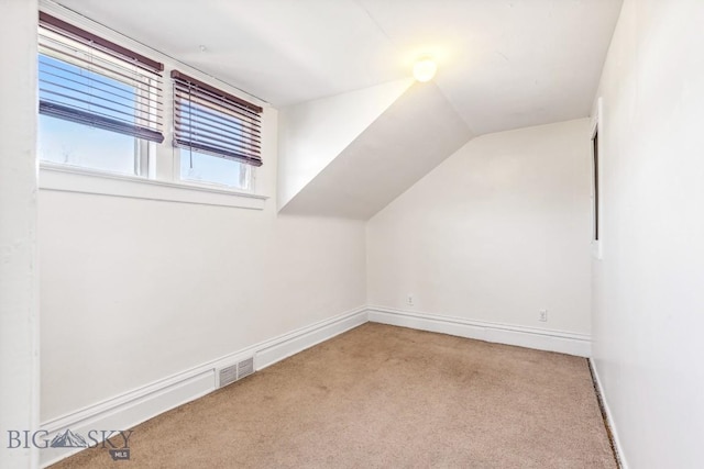 bonus room featuring baseboards, carpet floors, visible vents, and vaulted ceiling