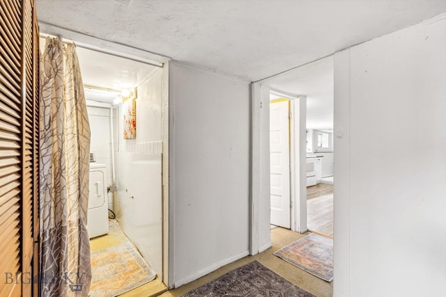 corridor with concrete floors and washer / dryer