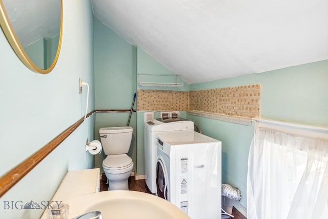 bathroom with toilet, vaulted ceiling, and washer / clothes dryer
