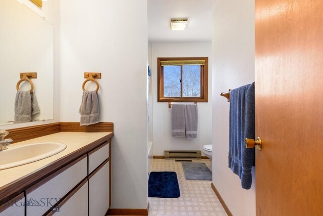 490 Secretariat Cir, Belgrade, MT 59714 - full bath featuring vanity, toilet, tile patterned floors, baseboards, and a baseboard heating unit