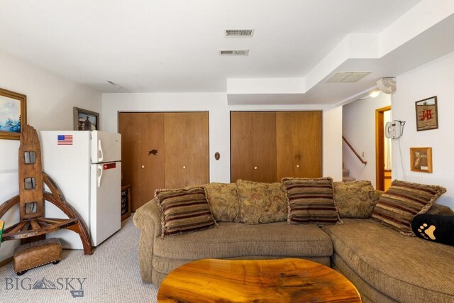 490 Secretariat Cir, Belgrade, MT 59714 - living area with visible vents, light carpet, and stairway
