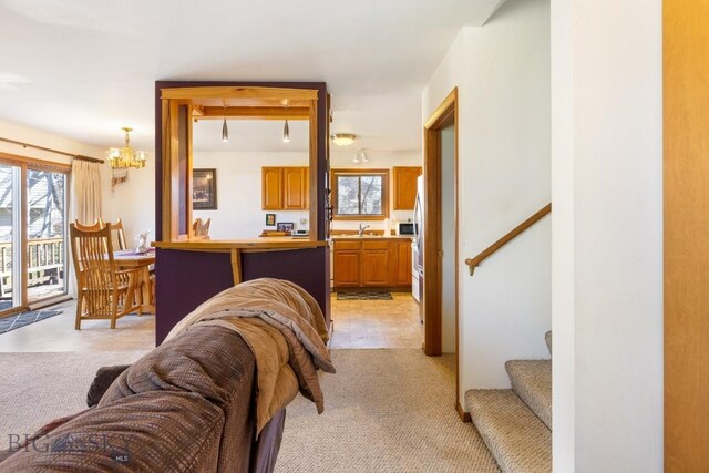 490 Secretariat Cir, Belgrade, MT 59714 - interior space with stairway, light carpet, and a notable chandelier