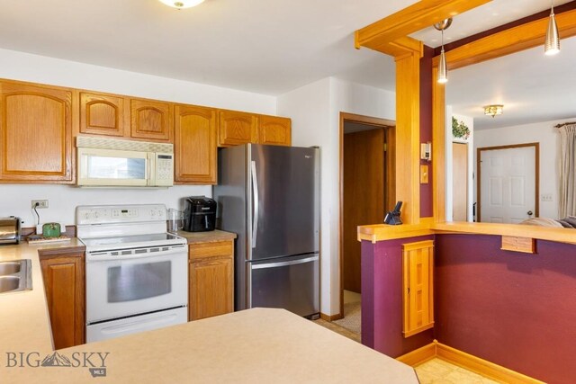 490 Secretariat Cir, Belgrade, MT 59714 - kitchen featuring white appliances, brown cabinetry, pendant lighting, and light countertops