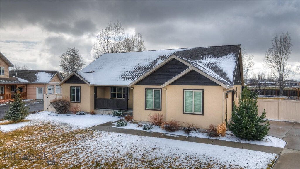 view of front of home featuring stucco siding and fence
