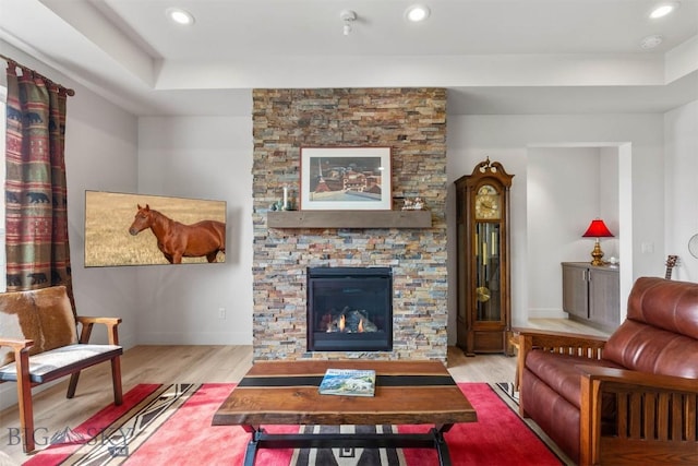 1510 Deadwood Loop, Belgrade, MT 59714 - living room featuring wood finished floors, a stone fireplace, a raised ceiling, and recessed lighting