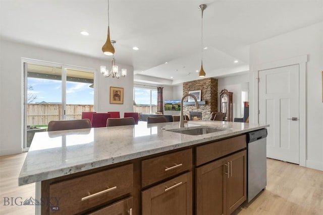 1510 Deadwood Loop, Belgrade, MT 59714 - kitchen featuring dishwasher, light wood finished floors, an island with sink, hanging light fixtures, and open floor plan