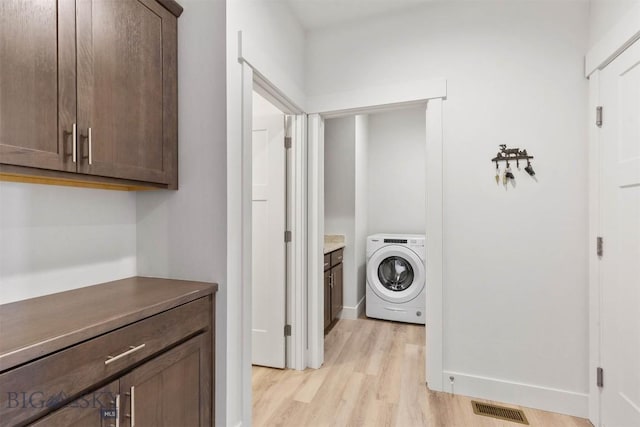 1510 Deadwood Loop, Belgrade, MT 59714 - laundry room with washer / dryer, light wood-style flooring, and cabinet space
