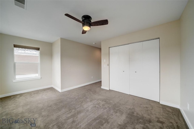unfurnished bedroom featuring baseboards, carpet flooring, and a closet