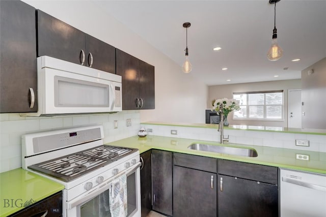 kitchen featuring light countertops, white appliances, a sink, and tasteful backsplash