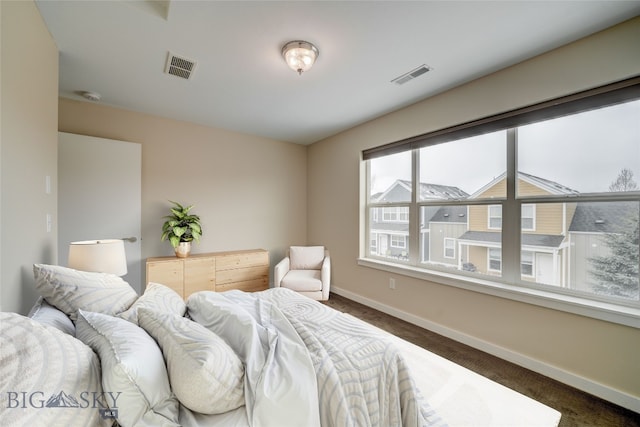 bedroom featuring dark carpet, visible vents, and baseboards