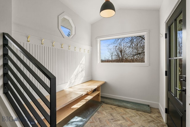 mudroom featuring brick floor, baseboards, and lofted ceiling