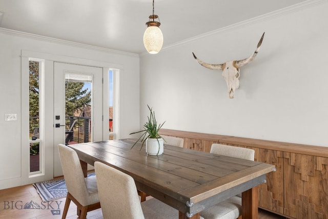 dining area featuring crown molding and light wood finished floors