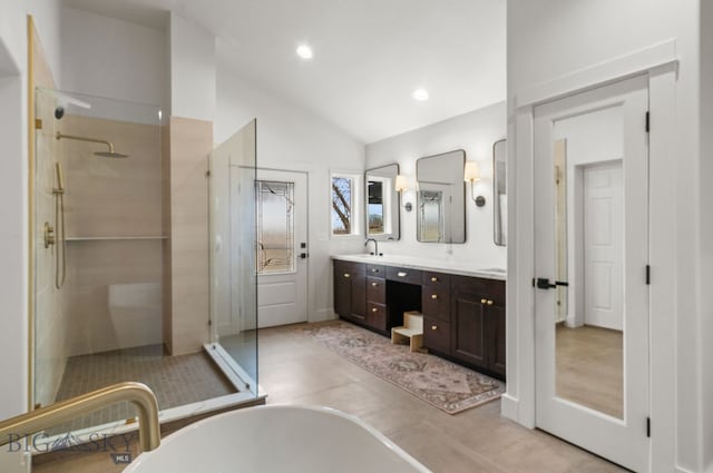 bathroom featuring a soaking tub, a walk in shower, recessed lighting, lofted ceiling, and double vanity
