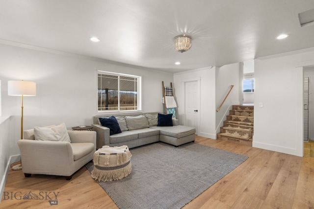 living area featuring wood finished floors, recessed lighting, ornamental molding, and stairway