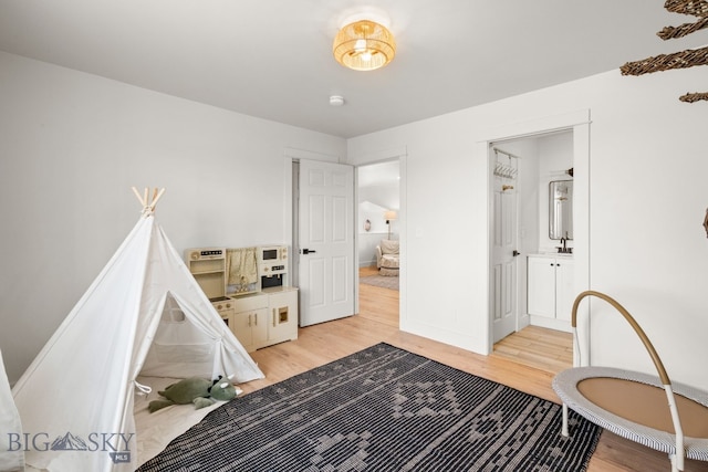 bedroom with light wood-style flooring and baseboards