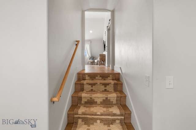 stairway with baseboards and wood finished floors