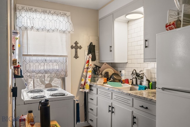 220 4th Ave E, Three Forks, MT 59752 - kitchen featuring white appliances, light countertops, white cabinets, decorative backsplash, and a sink