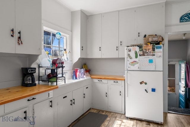 220 4th Ave E, Three Forks, MT 59752 - kitchen featuring butcher block counters, white cabinets, light wood-type flooring, and freestanding refrigerator